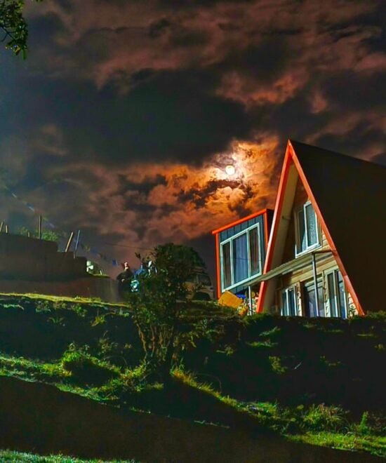 Night view of Tonglu Inn with illuminated windows under a moonlit sky