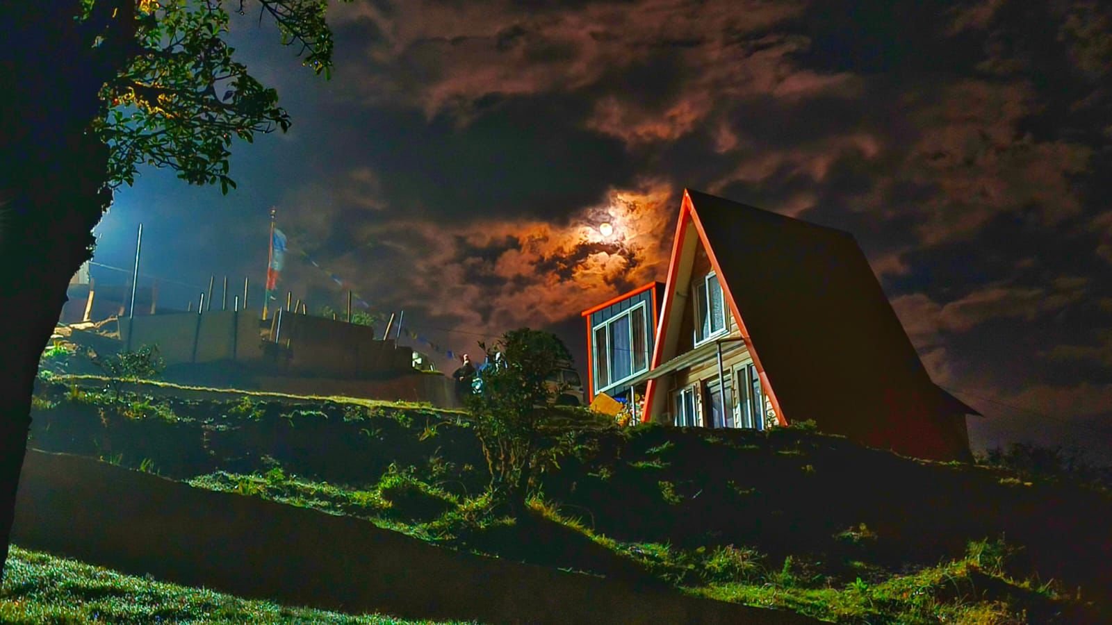 Night view of Tonglu Inn with illuminated windows under a moonlit sky